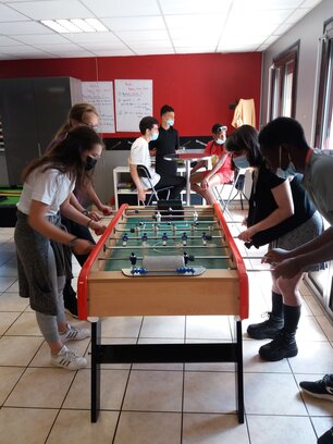 Des adolescents jouent en équipe au baby-foot